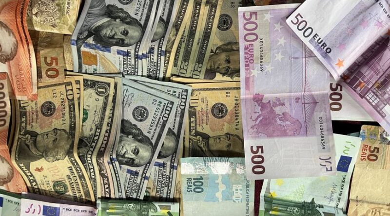 Rozłożone banknoty różnych walut świata, w tym dolary amerykańskie i euro.